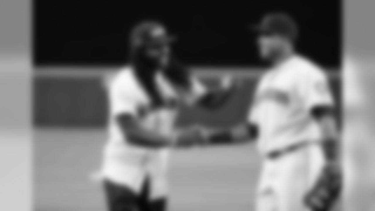 Seattle Seahawks' Richard Sherman, left, greets Seattle Mariners' Nelson Cruz after Sherman threw out the ceremonial first pitch before a baseball game between the Mariners and New York Yankees Tuesday, June 2, 2015, in Seattle. (AP Photo/Elaine Thompson)