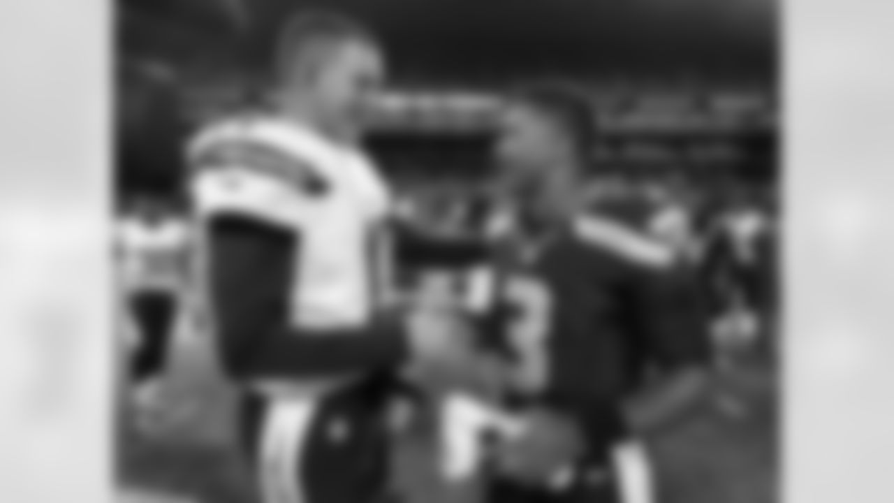 Seattle Seahawks quarterback Russell Wilson (3) visits with San Diego Chargers quarterback Philip Rivers after the Seahawks defeated the Chargers 41-14 in a preseason NFL football game, Friday, Aug. 15, 2014, in Seattle. (AP Photo/John Froschauer)