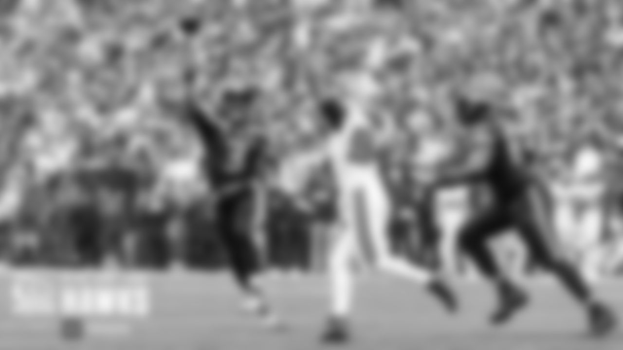 Seahawks quarterback Russell Wilson rolls to his right and fires a touchdown pass to Tyler Lockett in the end zone.