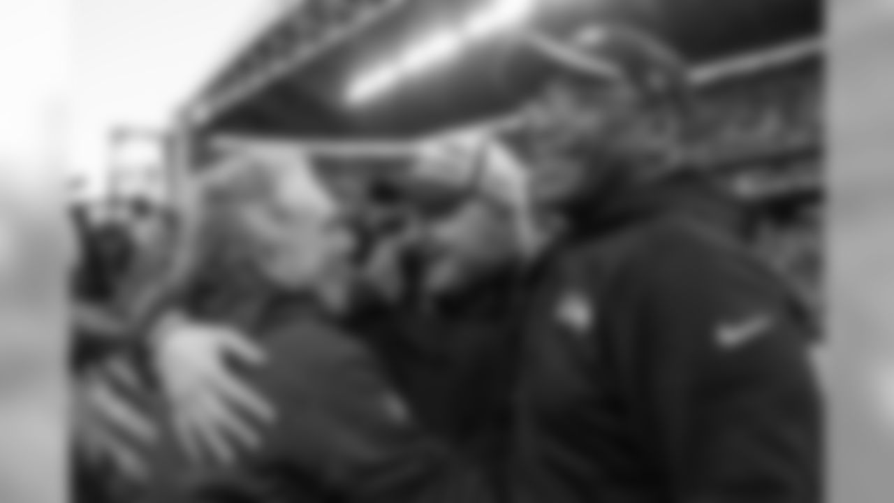 Offensive coordinator Darrell Bevell celebrates with quarterbacks coach Carl Smith (left) and Sherman Smith (right) on the field after the game.