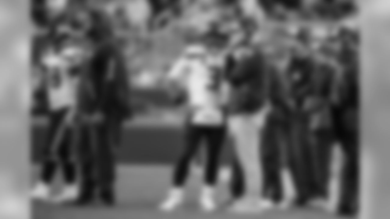 Seahawks quarterback Russell Wilson and offensive coordinator Brian Schottenheimer meet near the sideline during a break in the action.