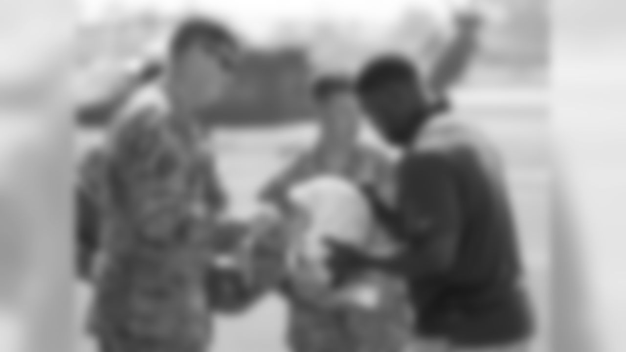 Cincinnati Bengals Gene Atkins, right, signs an autograph for some United States Army personnel before the NFL Pro Bowl Football Draft at the Wheeler Army Airfield, Wednesday, Jan. 27, 2016, in Wahiawa, Hawaii. (AP Photo/Eugene Tanner)