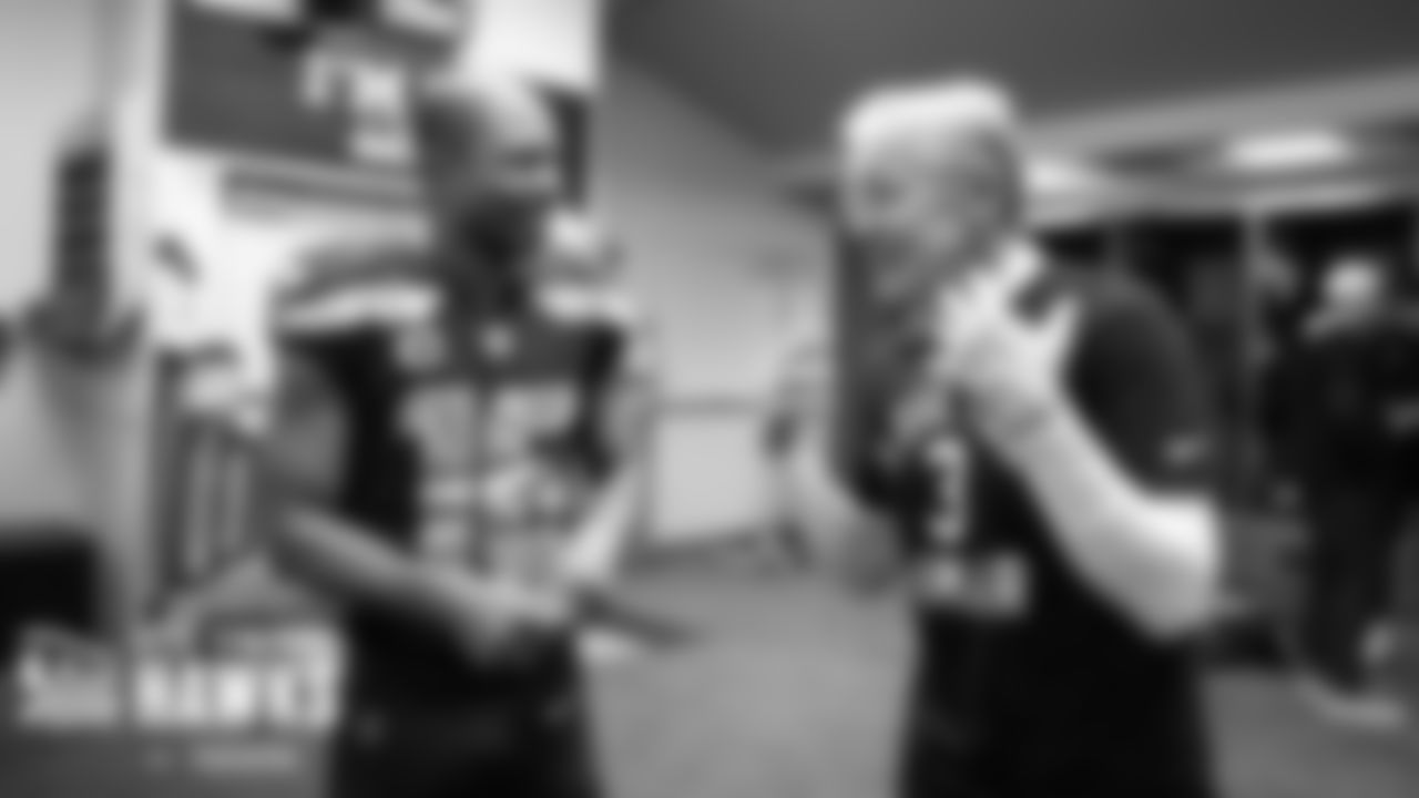 Receiver Tyler Lockett and head coach Pete Carroll talk in the locker room after the game. Lockett tallied his fourth season with 1000 receiving yards.