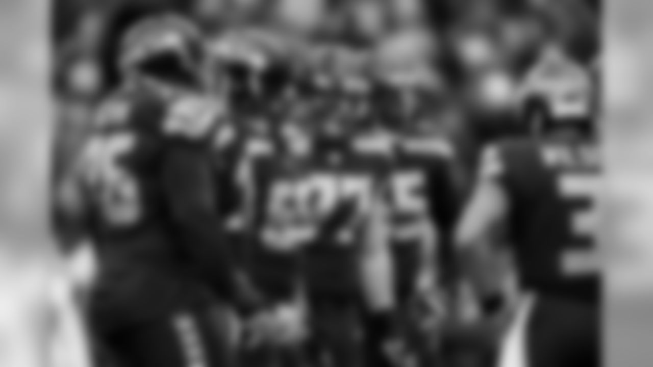 The offensive line waits for quarterback Russell Wilson to enter the huddle.