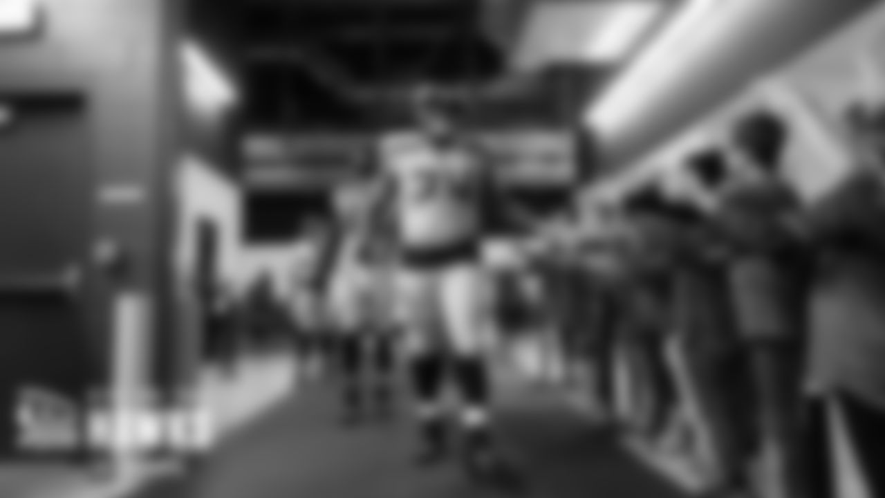 Seahawks offensive tackle George Fant slaps hands with young fans watching the team head from the locker room to the field.
