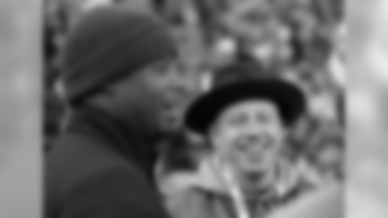 Rapper Macklemore, right, and former Seattle Mariners star Ken Griffey Jr., left, stand on the sideline before an NFL football game between the Seattle Seahawks and the San Francisco 49ers, Sunday, Dec. 14, 2014, in Seattle. (AP Photo/Elaine Thompson)