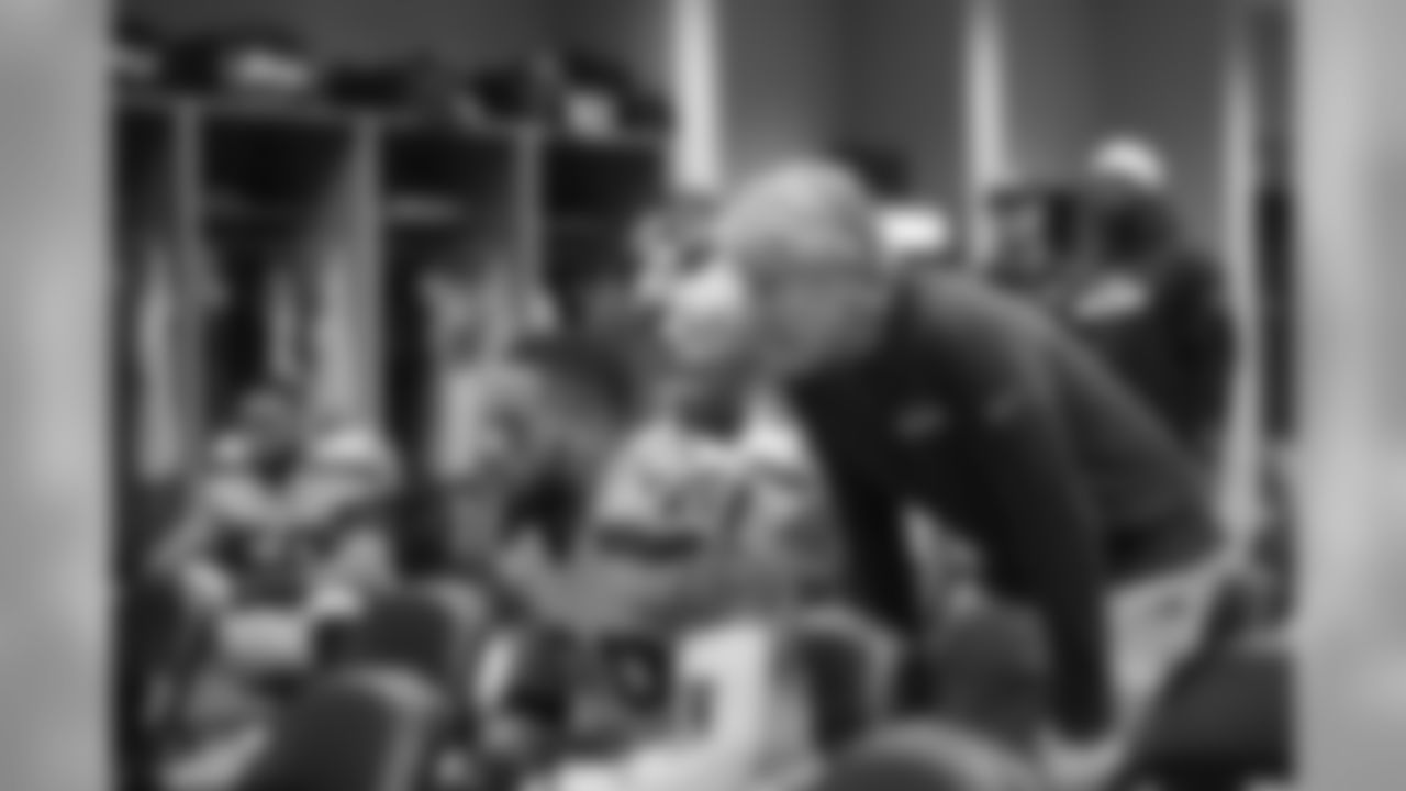 Head coach Pete Carroll watches over the shoulder of safety Earl Thomas in the locker room as they listen to defensive coordinator Kris Richard give instructions.