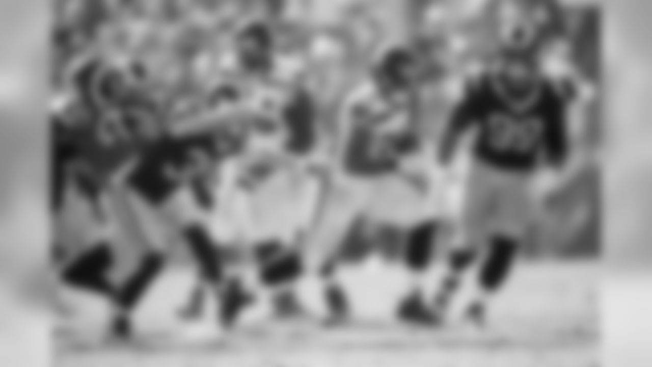 Seattle running back Thomas Rawls runs past a host of Rams.