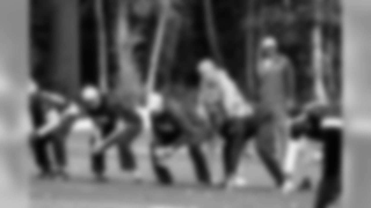 Head coach Pete Carroll plays quarterback with members of the practice squad and assistant coaches as they work with the defense during practice.