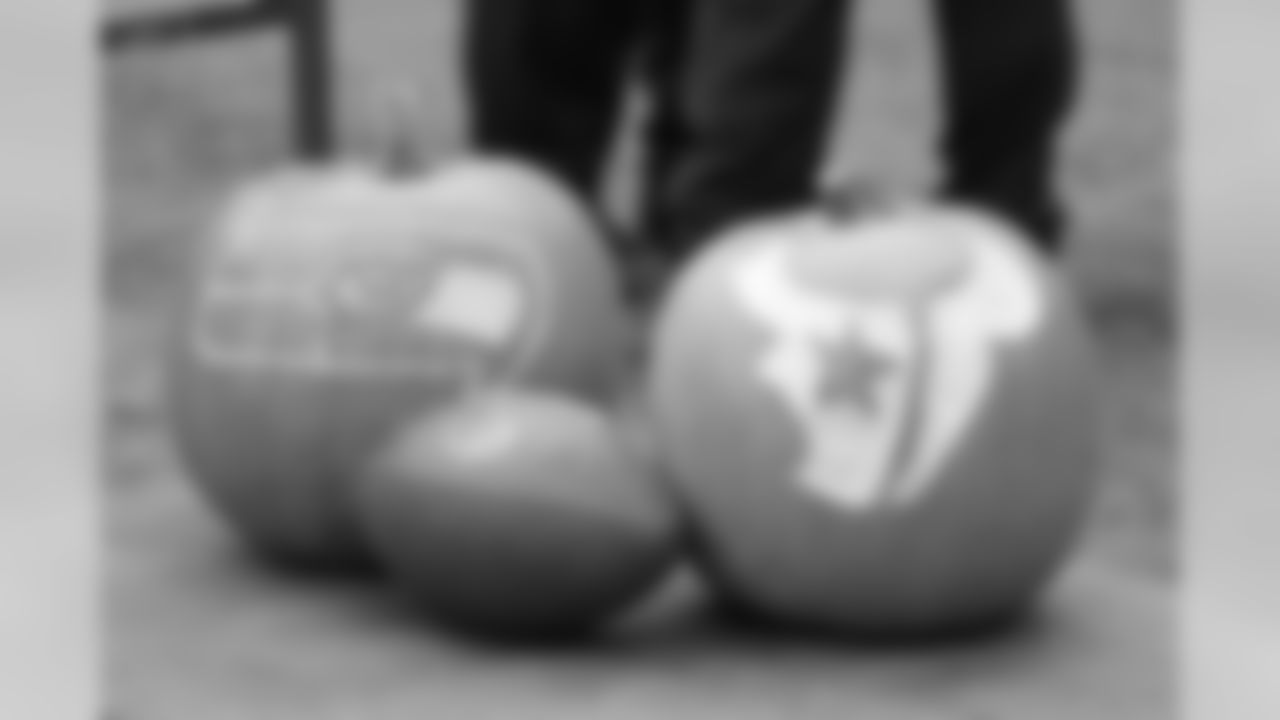 Halloween pumpkins carved with the logos of the Seattle Seahawks and the Houston Texans rest on a cart before an NFL football game, Sunday, Oct. 29, 2017, in Seattle. (AP Photo/Elaine Thompson)