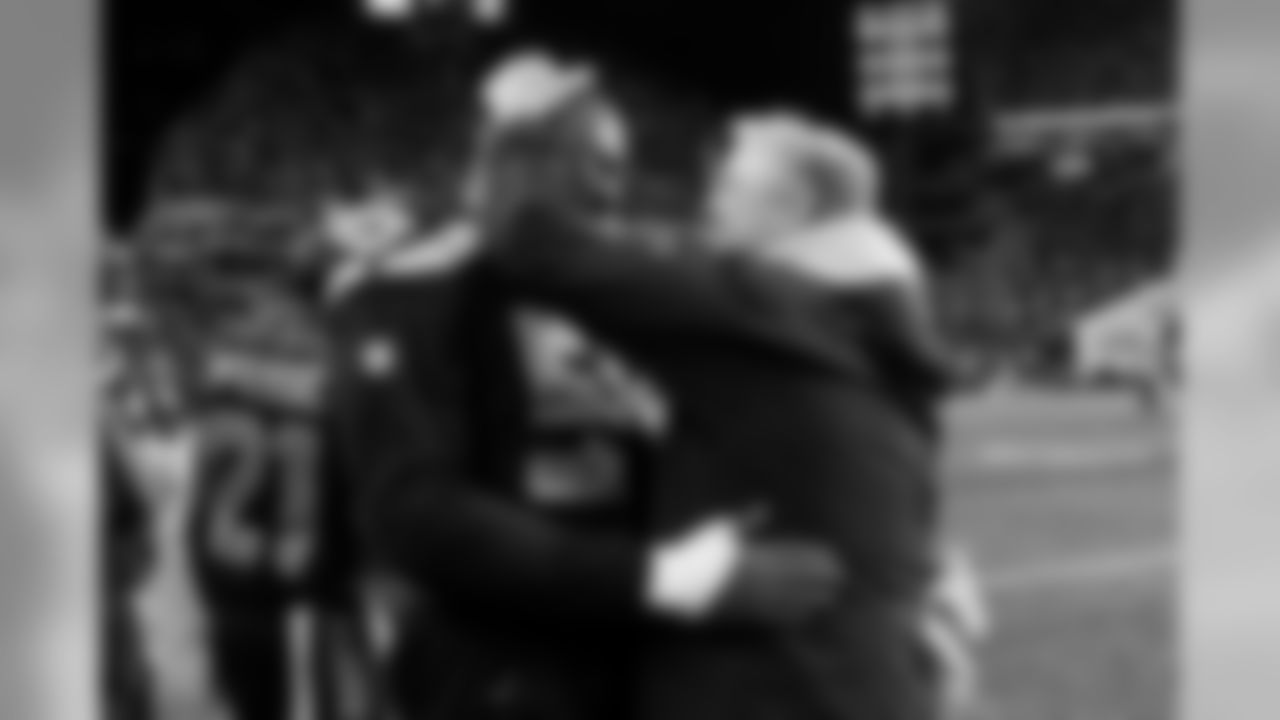 Defensive end Frank Clark and head coach Pete Carroll celebrate as the offense takes the victory formation to seal the victory.
