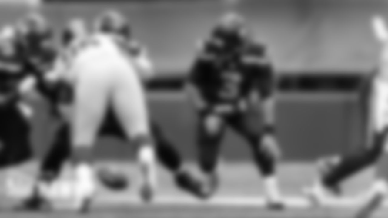Seahawks quarterback Russell Wilson looks for the loose ball after fumbling the exchange from center.