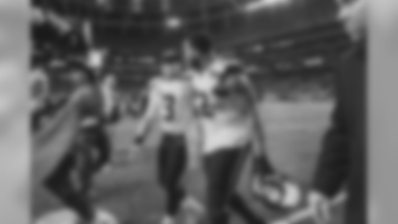 Quarterback Russell Wilson and defensive lineman Michael Bennett walk off the field together after the game.