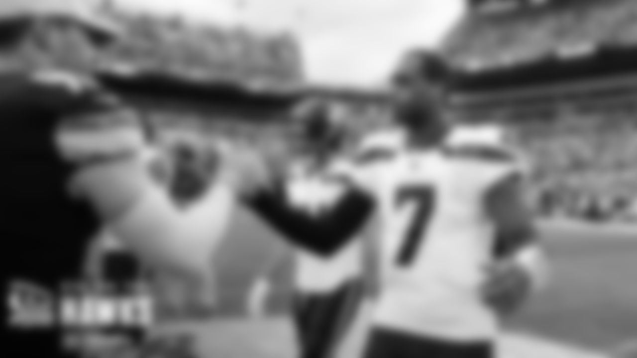 Quarterback Geno Smith greets Steelers defender T.J. Watt during the pregame coin toss.
