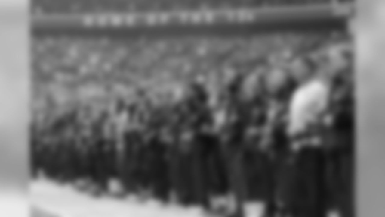 Seahawks players and coaches link arms in unity during the playing of the national anthem.