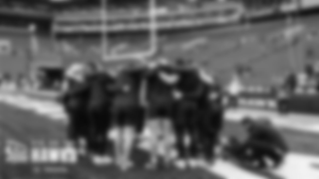 Seahawks quarterbacks, receivers and tight ends huddle on the field during pregame.