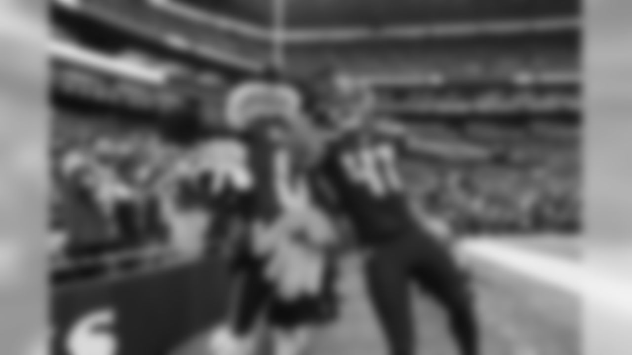 Seahawks special teamer George Farmer leaps with Seahawks mascot Blitz after running downfield on a kickoff.
