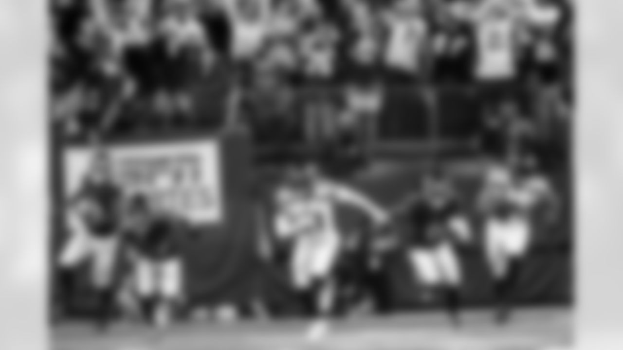Seattle's first-year cornerback Devon Witherspoon races the other way with an interception near the goal line as Seahawks and Giants fans react differently in the stands.