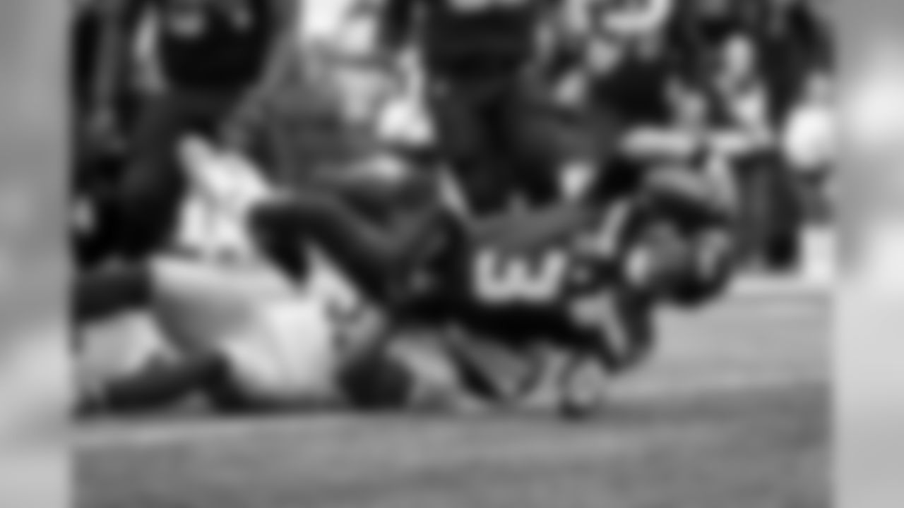 Seahawks quarterback Russell Wilson stretches towards the line to gain for a first down.