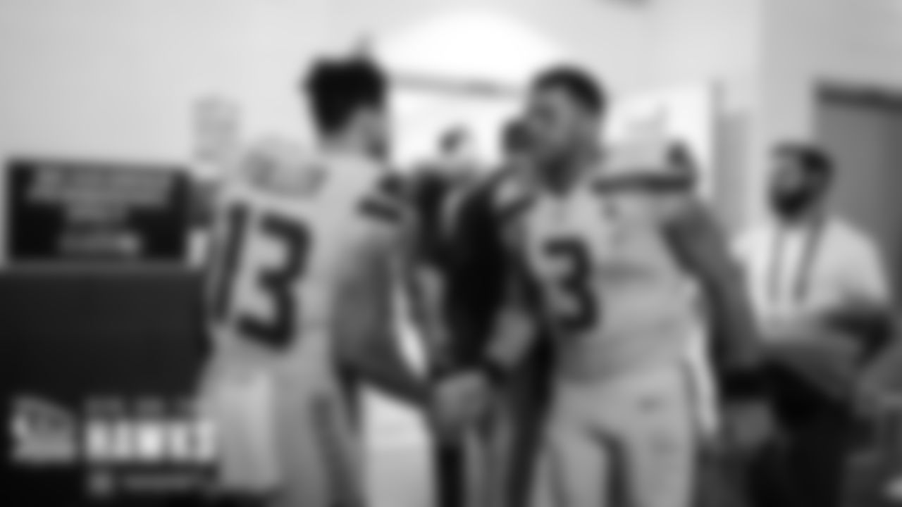 Russell Wilson waits outside the locker room at halftime to greet teammates including Aaron Fuller.