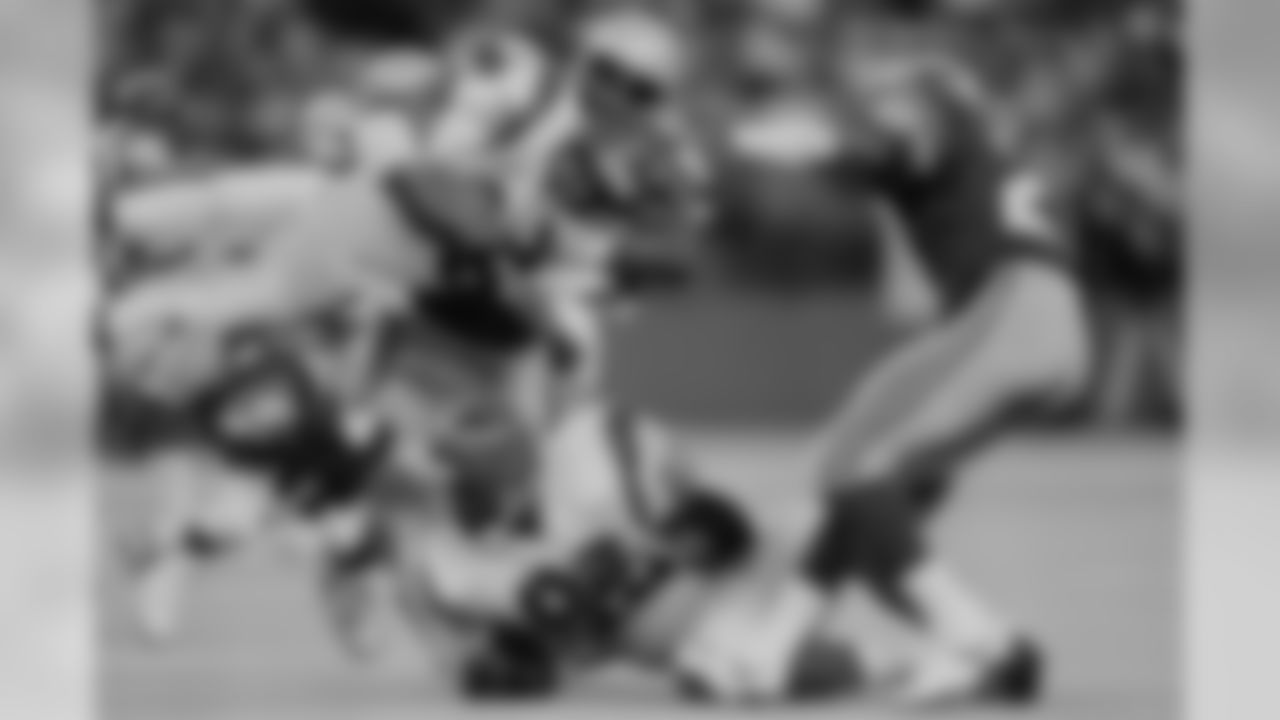 Stanford Jennings, center, of the Cincinnati Bengals is tackled by Nesby Glasgo, bottom, and Cortez Kennedy (96) of the Seattle Seahawks during the fourth quarter of NFL game in Seattle, Oct. 2, 1990. (AP Photo/Bill Chan)