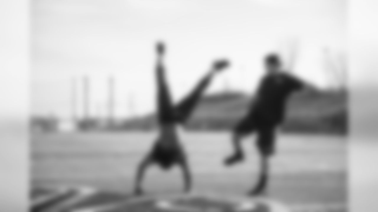 Receiver Kevin Smith shows off his handstand skills as offensive lineman J.R. Sweezy does his best impression of kicker Steven Hauschka.