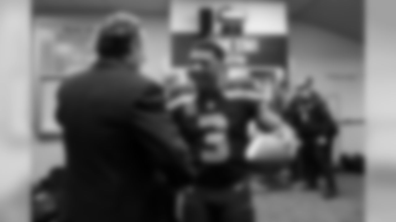 Seahawks quarterback Russell Wilson is congratulated by team president Peter McLoughlin in the locker room after the game. Wilson is holding the Sunday Night Football Player of the game ball, which he was awarded after the game.