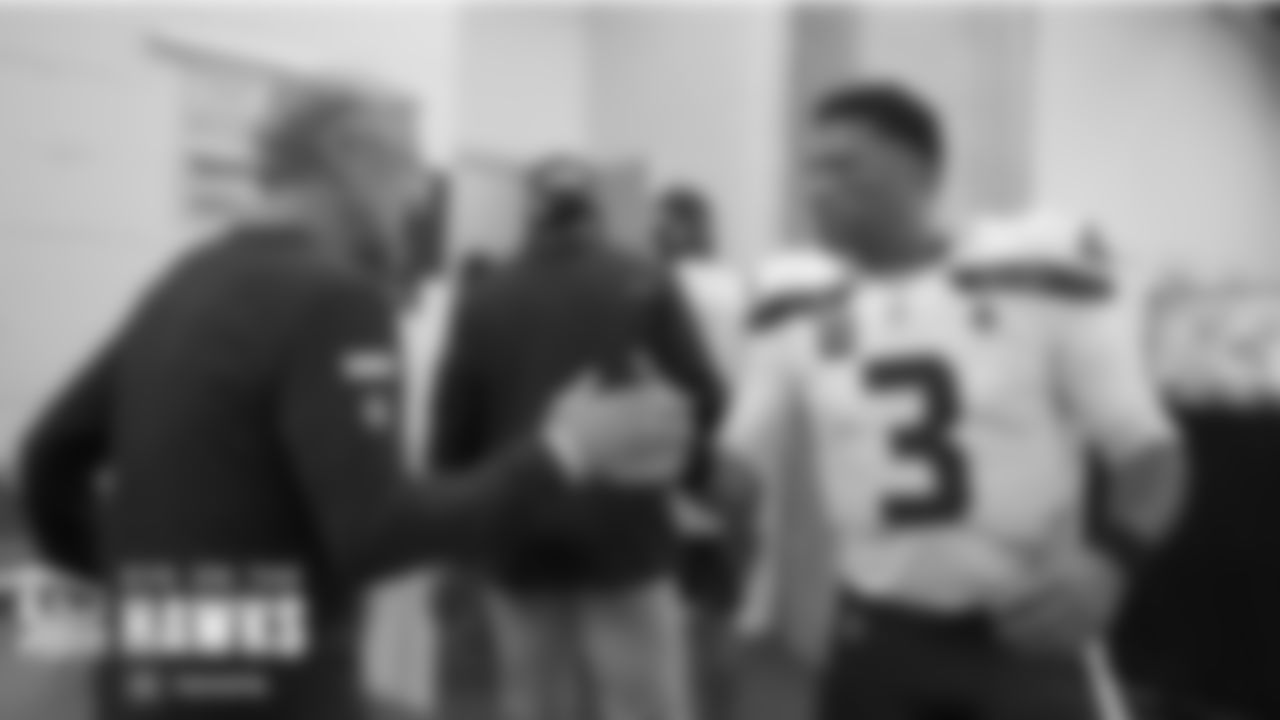 Quarterback Russell Wilson greets and shouts encouragement to head coach Pete Carroll along with every player, coach and staff member as they return to the locker room after pregame warmups.