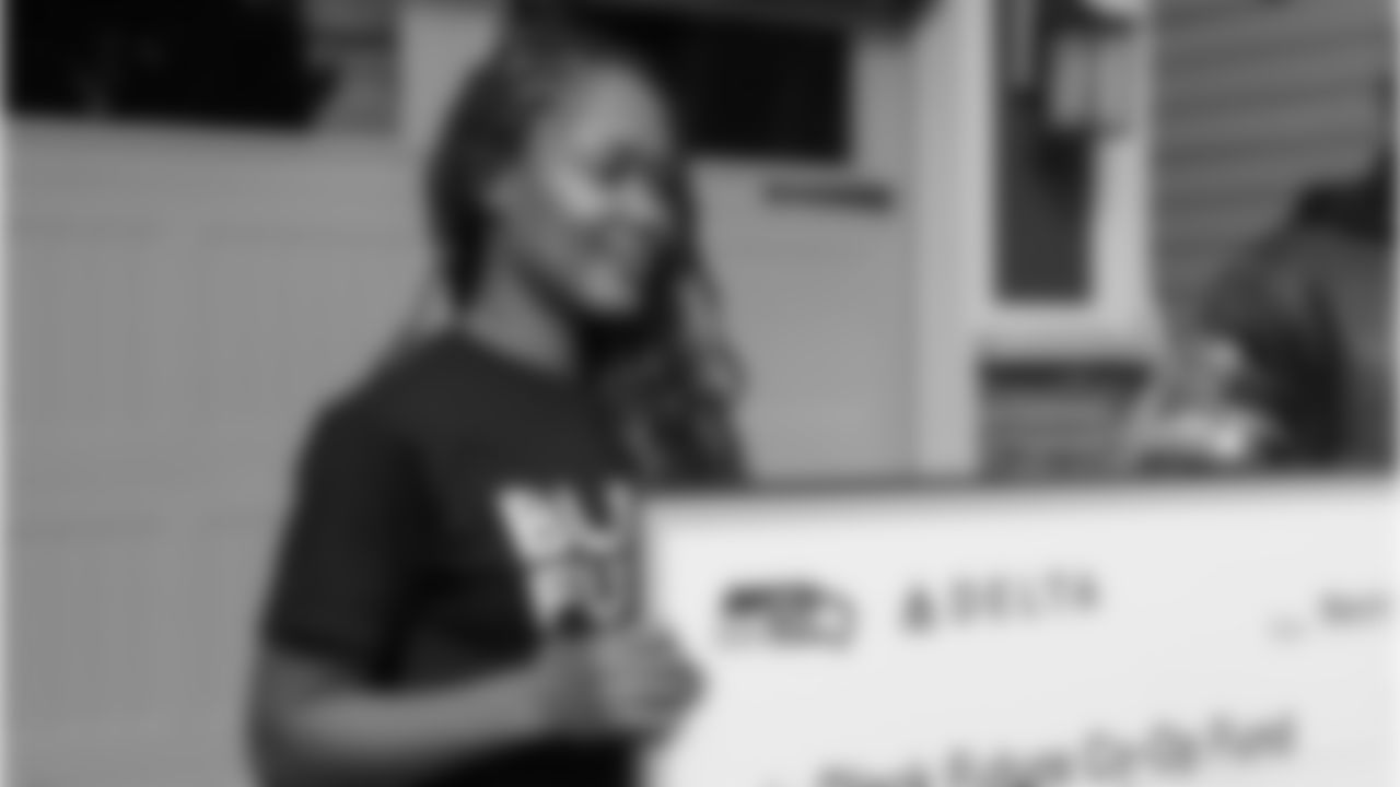 Black Future Co-Op Fund Architect, Andrea Caupain Sanderson, accepts a $10,000 donation from Seahawks Legend Neiko Thorpe on behalf of the Seahawks and Delta Air Lines.