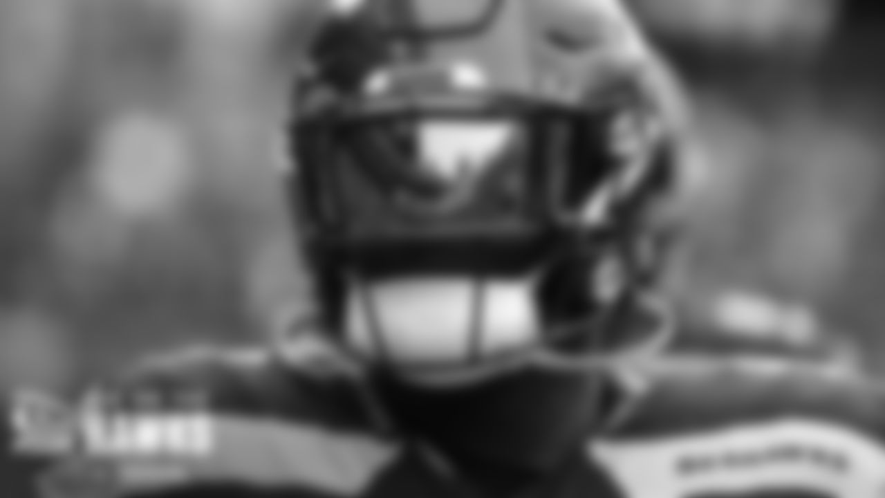Lumen Field is reflected in the face shield worn by Poona Ford.