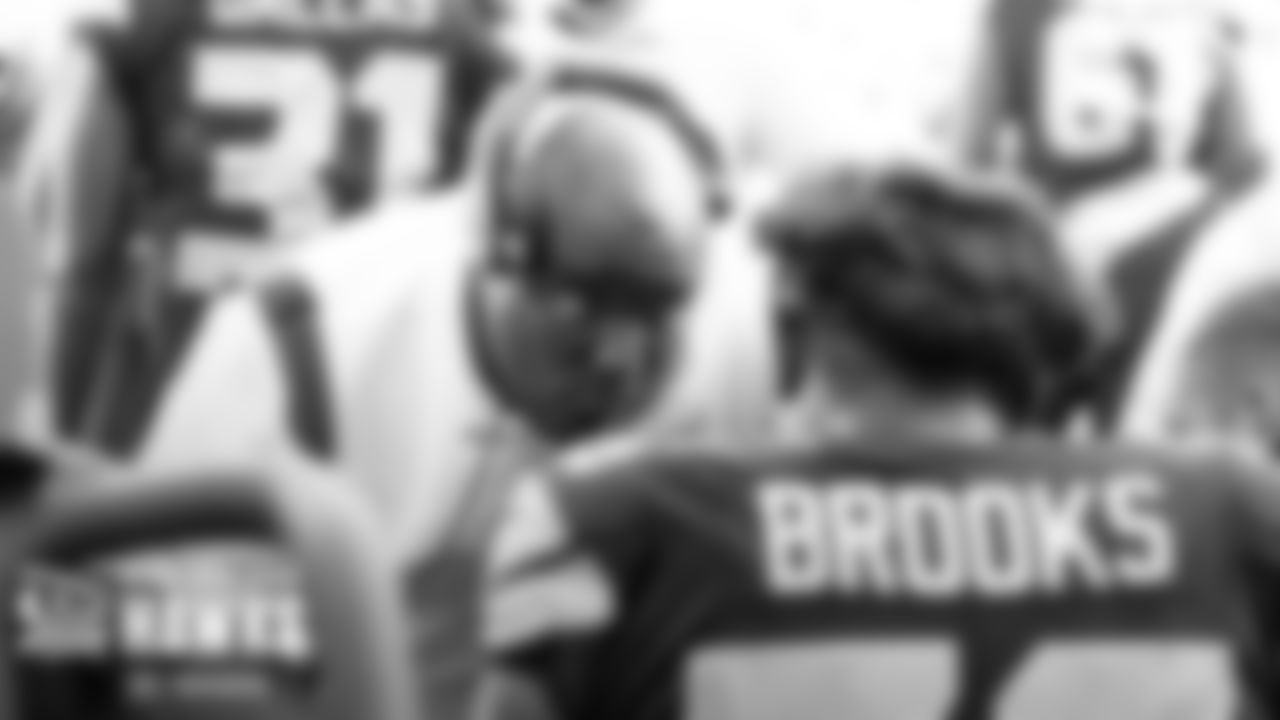 Seahawks defensive coordinator Clint Hurtt gives instructions to linebacker Jordyn Brooks on the sidelines.