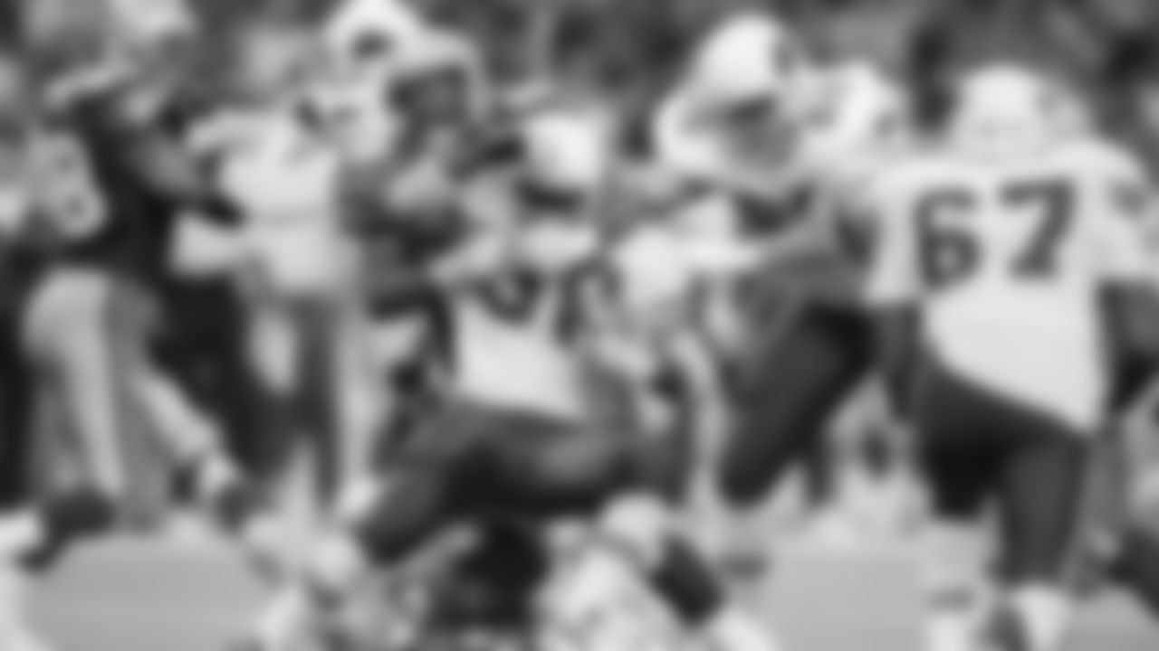 Running back Ron Moore (30) of the Phoenix Cardinals is held to a one yard gain as he is tackled by Cortez Kennedy (96) of the Seattle Seahawks during the third quarter of their NFL game in Seattle, Washington, Dec. 19, 1993. Watching the play is Joe Wolf (68) of the Cardinals. Phoenix beat Seattle in overtime, 30-27. (AP Photo/Bill Chan)