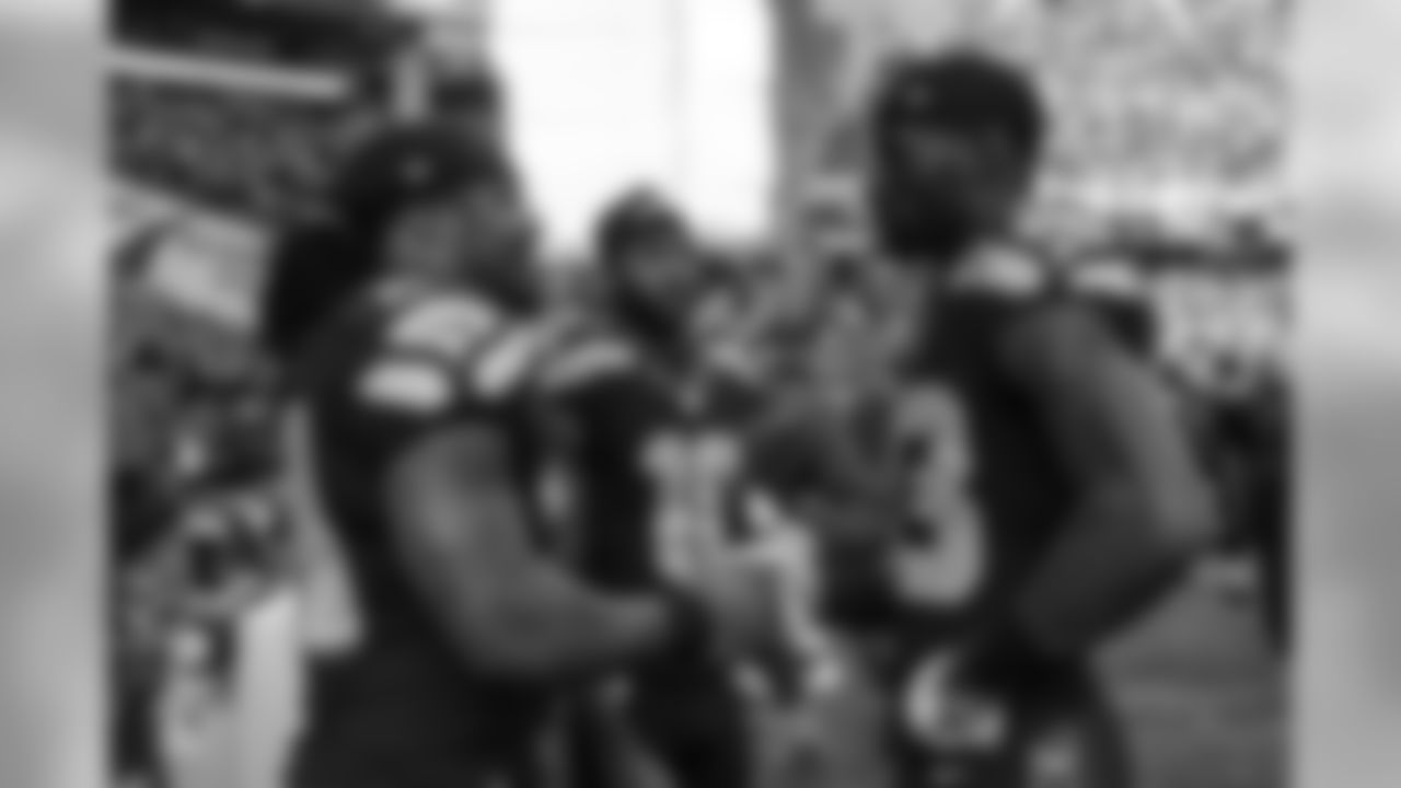 Running back Marshawn Lynch talks to young receivers Ricardo Lockette and Paul Richardson on the Seahawks sideline just before kickoff.