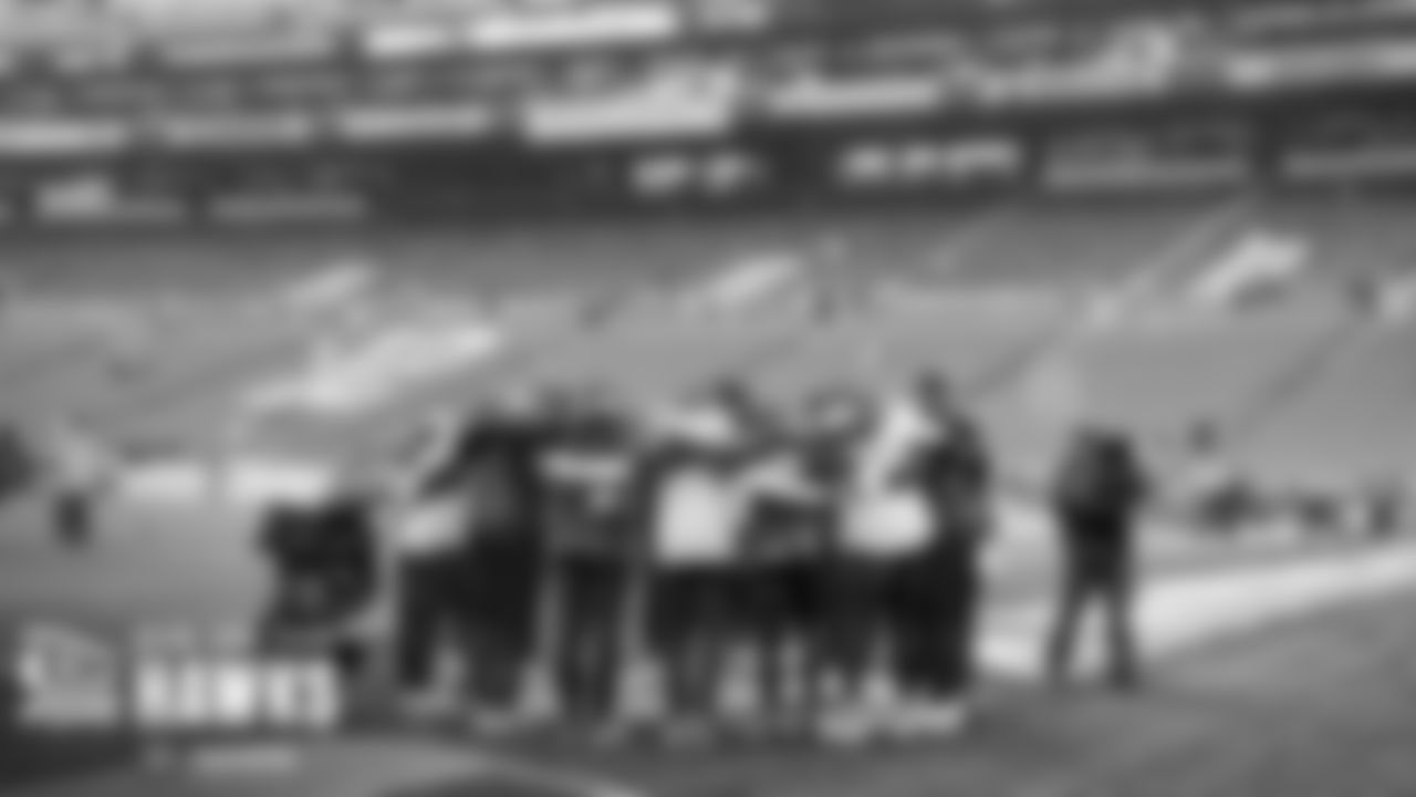 Seahawks offensive skill position players huddle at the end of their early warmups.