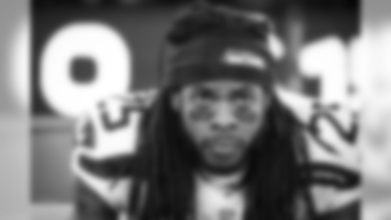 Cornerback Richard Sherman focuses while sitting on the sidelines during the extended pregame ceremonies of the Super Bowl.