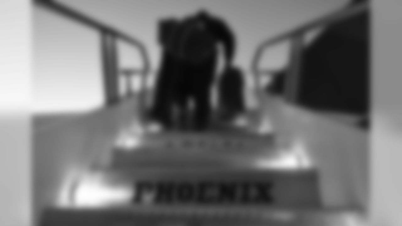 Defensive lineman Brandon Mebane walks up stairs to board the charter flight to Phoenix.