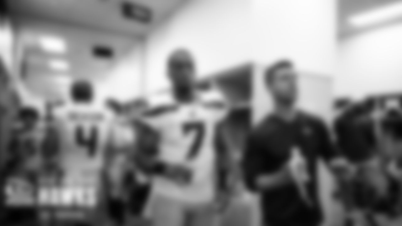 At halftime, Geno Smith and quarterbacks coach Dave Canales listen to offensive coordinator Shane Waldron as he talks to the offense in the locker room.