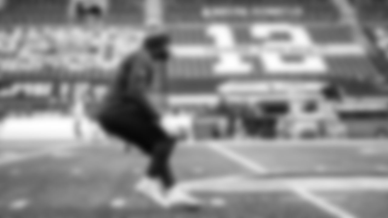 On the field, linebacker Jordyn Brooks does his early pregame warmups.