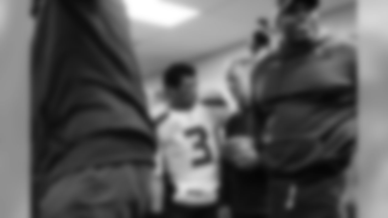 Quarterback Russell Wilson and his position coach Carl Smith share a quite moment amid the raucous celebration inside the winning locker room.