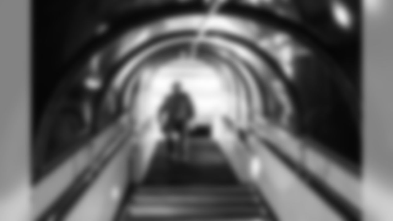 Upon arrival in Chicago late Saturday night, kicker Sebastian Janikowksi descends the stairs from the airplane to the tarmac and waiting buses.