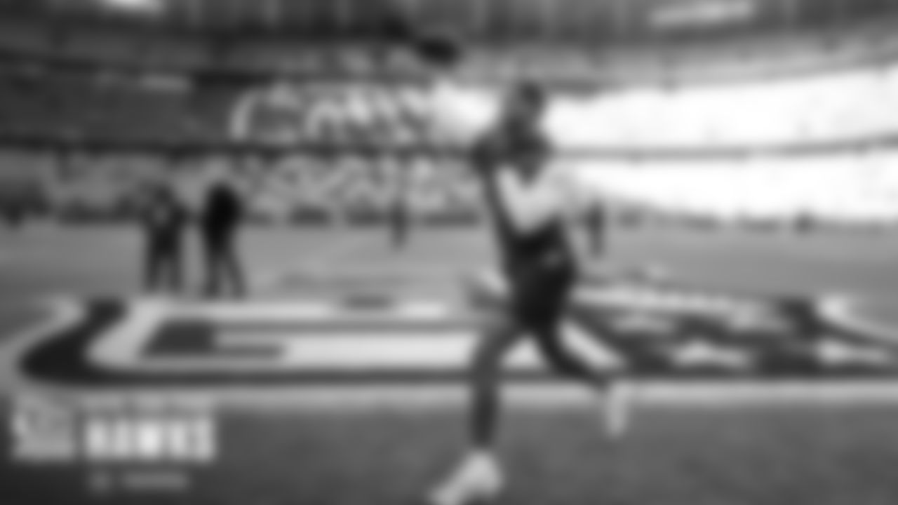 On the field, quarterback Geno Smith takes his early warmup throws.
