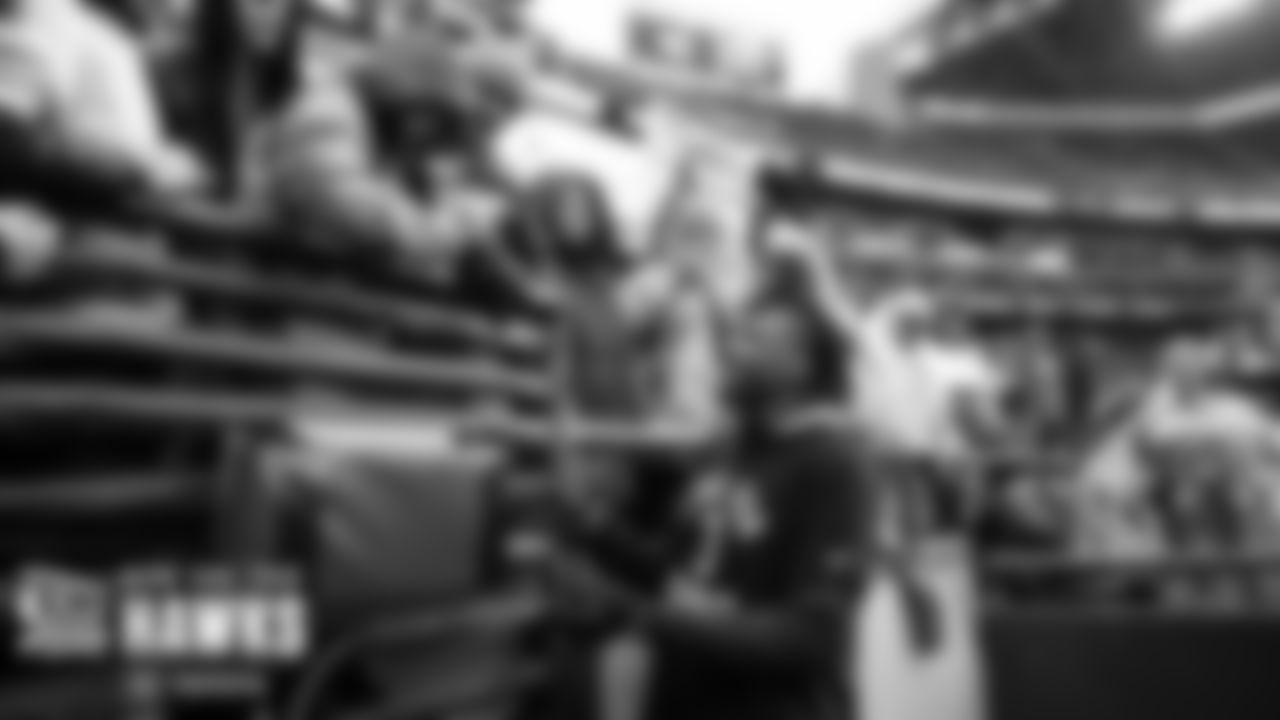 Cornerback Tariq Woolen, a fan favorite, plays "rock, paper, scissors" with a young fan before the game.