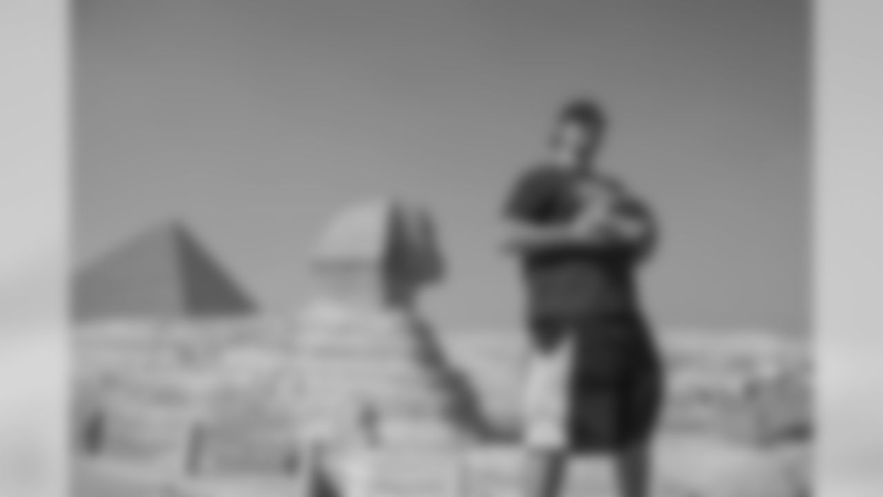 In this Monday, Feb. 29, 2016 photo, Breno Giacomini of the New York Jets, visits the Pyramids of Giza, in Cairo, Egypt. The players are on a visit to Egypt with American Football Without Barriers, a non-profit organization that educates disadvantaged children in the United States and overseas. In conjunction with the Egyptian Federation of American Football, AFWB will have free camps basic, junior and advanced levels for players ages 14-25, as well as a coaching clinic led by Breno Giacomini. (AP Photo/Roger Anis)