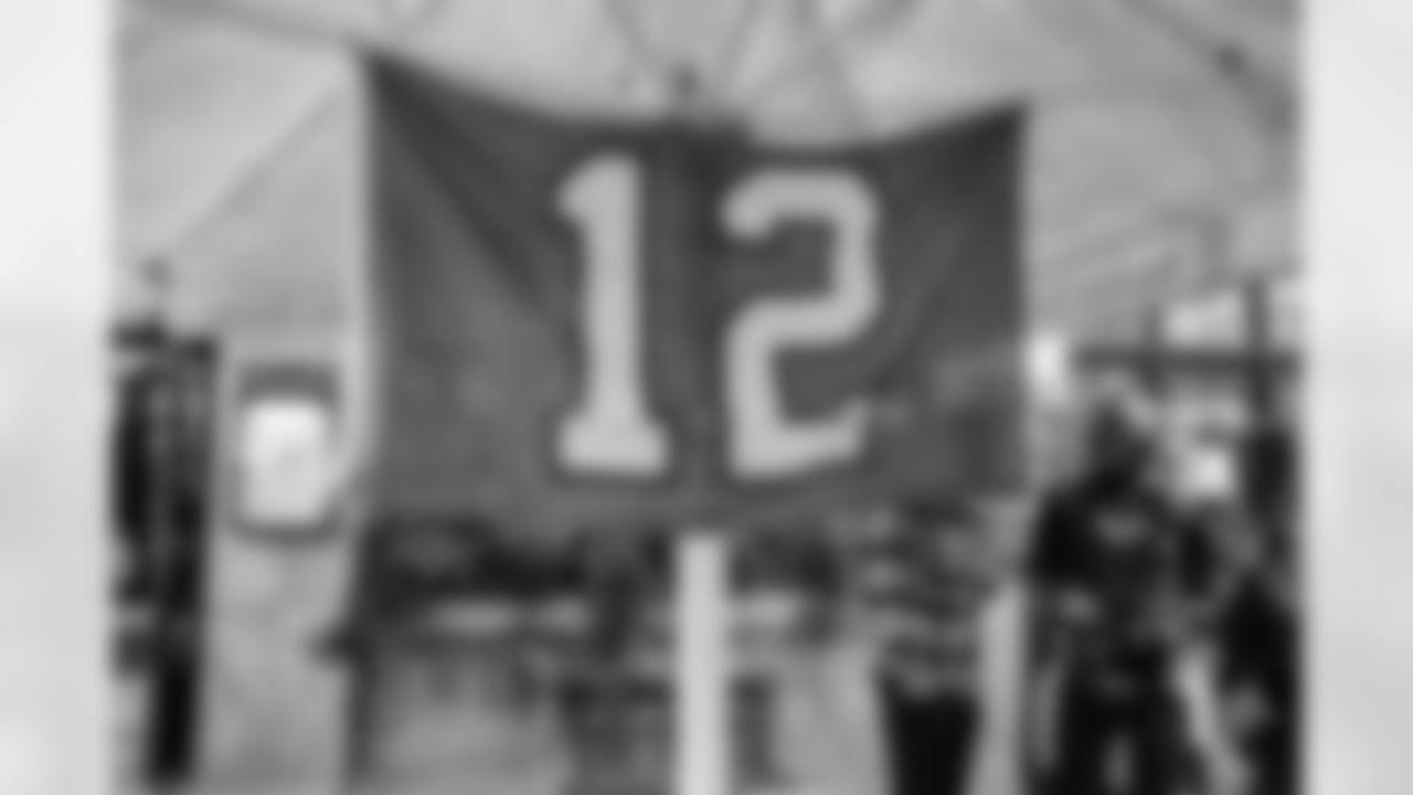 A number 12 flag (representing the fans) ans a Seahawks fan in a super hero costume hang outside the Seattle Seahawks Pub Event at the Augustiner Stammhaus pub, on Friday, Nov. 11 2022 in Munich. (AP Photo/Omer Messinger)