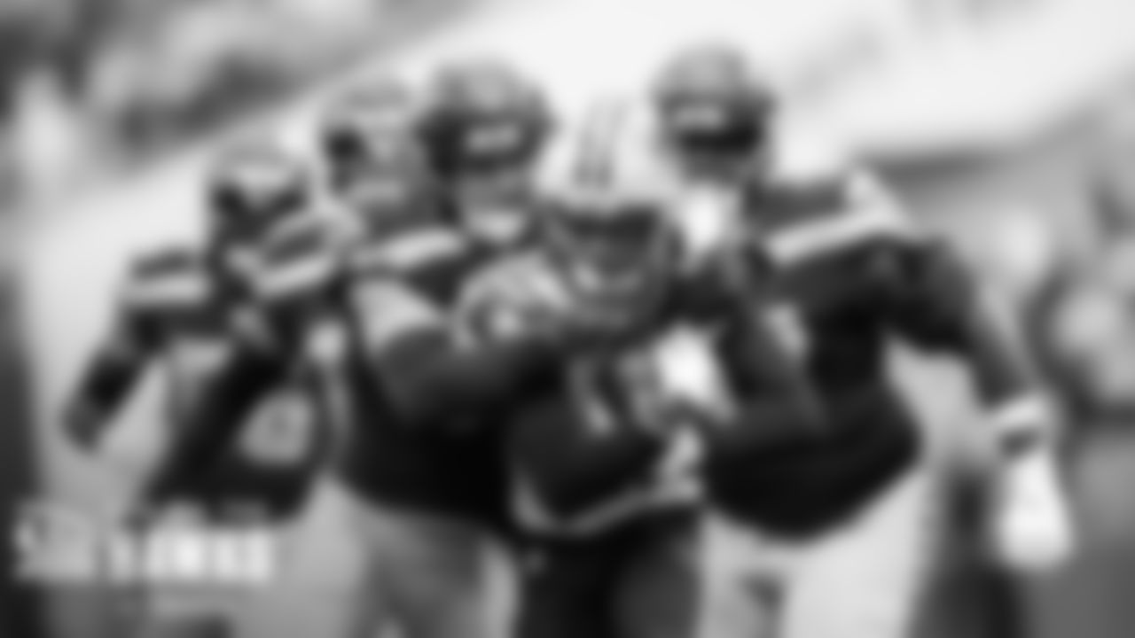 Seahawks linebacker Cody Barton makes a tackle as teammates close in.
