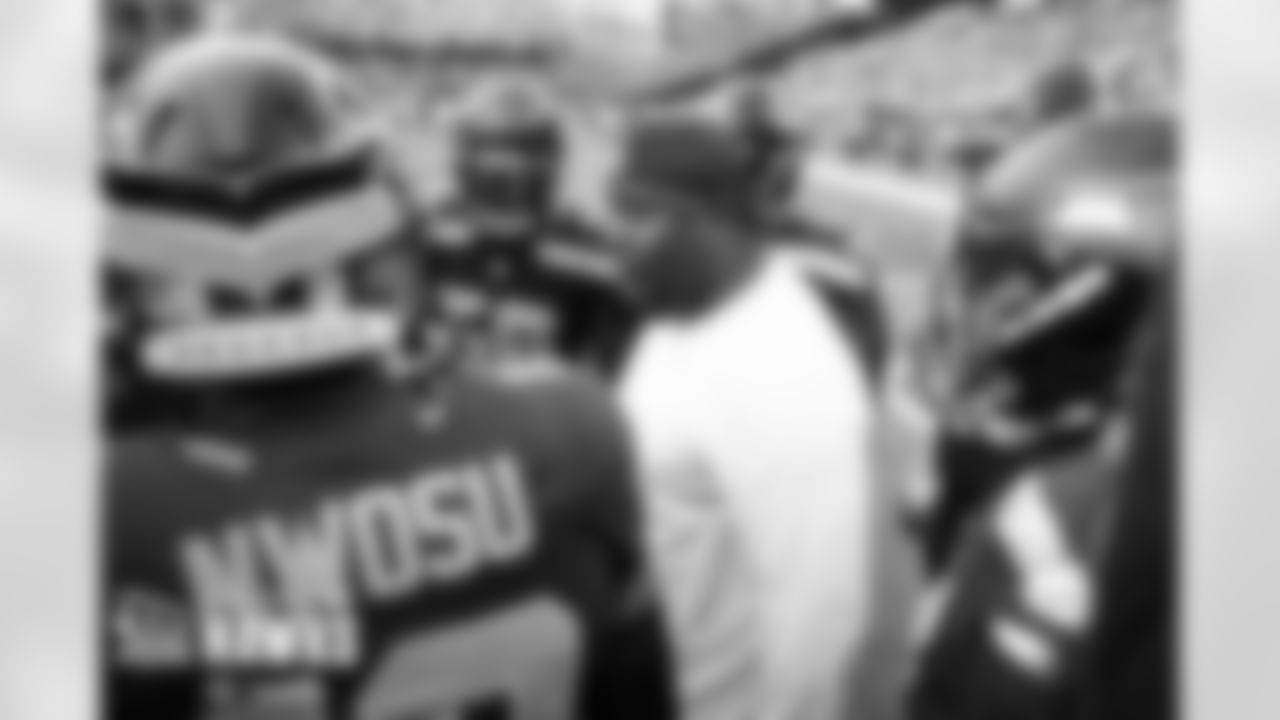 Seahawks assistant Damione Lewis gives intructions to members of the defensive line during pregame warmups.