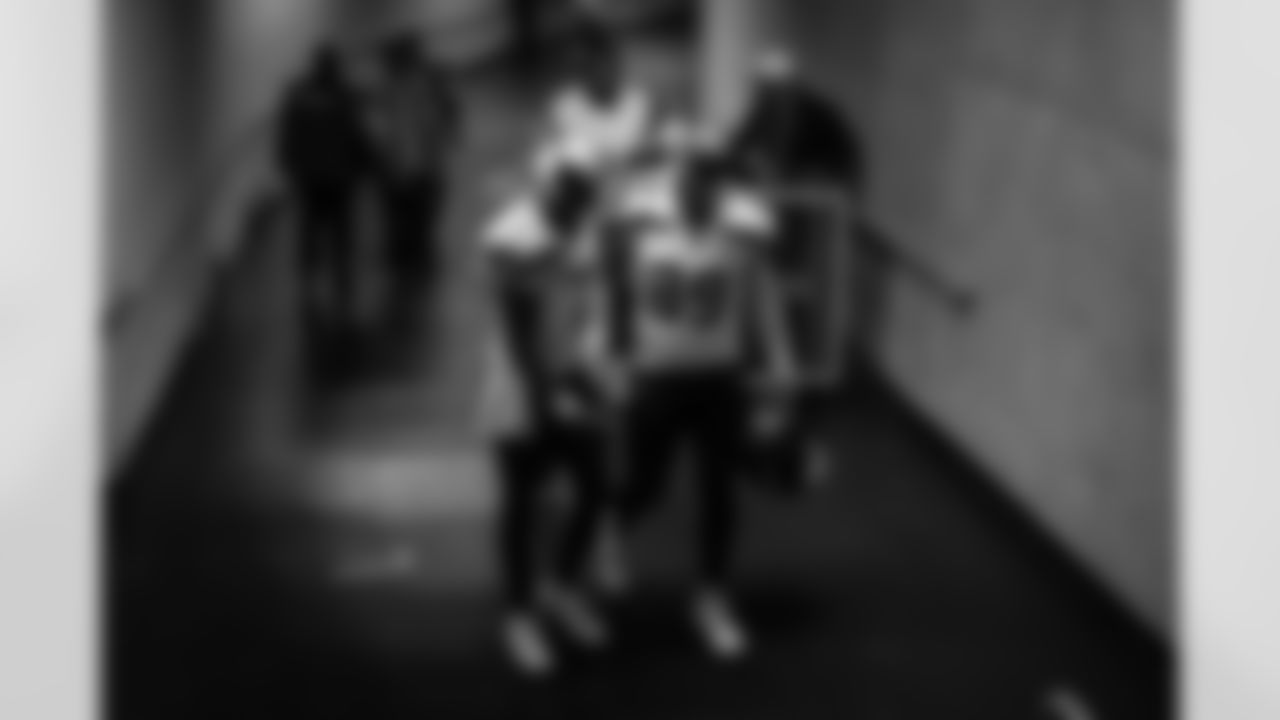Geno Smith and Will Dissly walk up the dark tunnel leading from the field to the locker room after the game.
