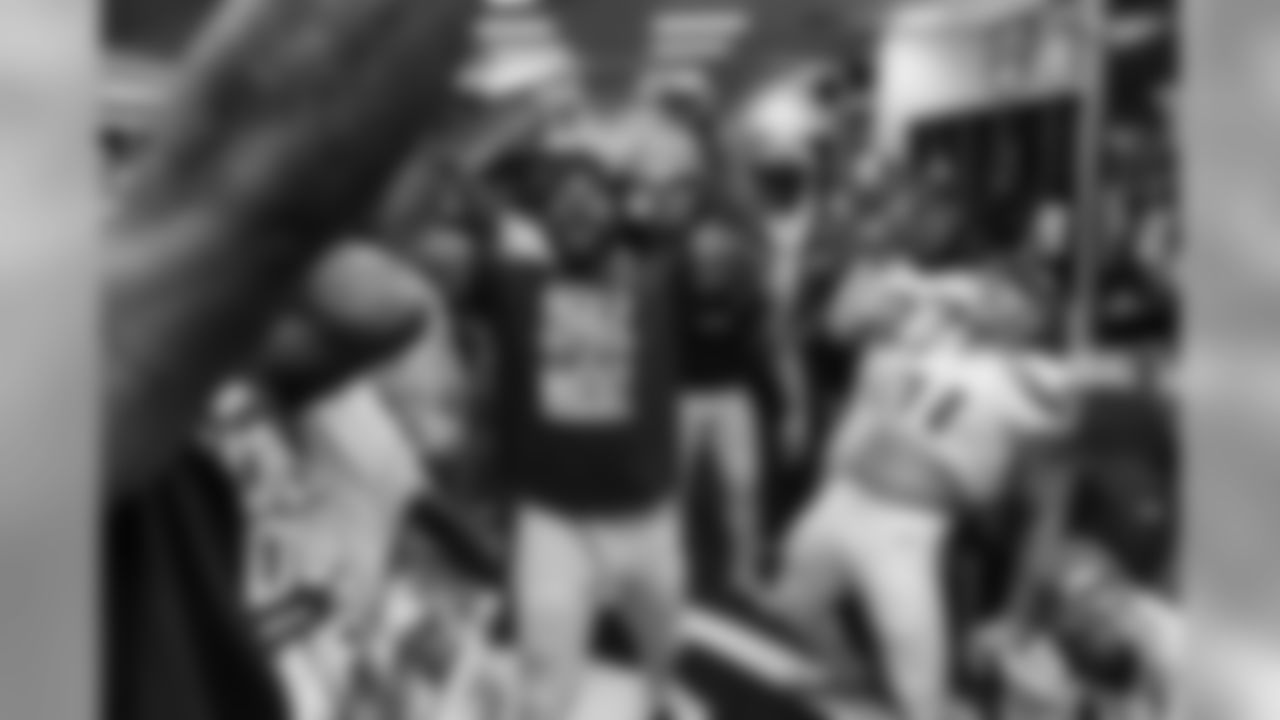 Michael Bennett leads a cheer as the team celebrates in the locker room after the game.