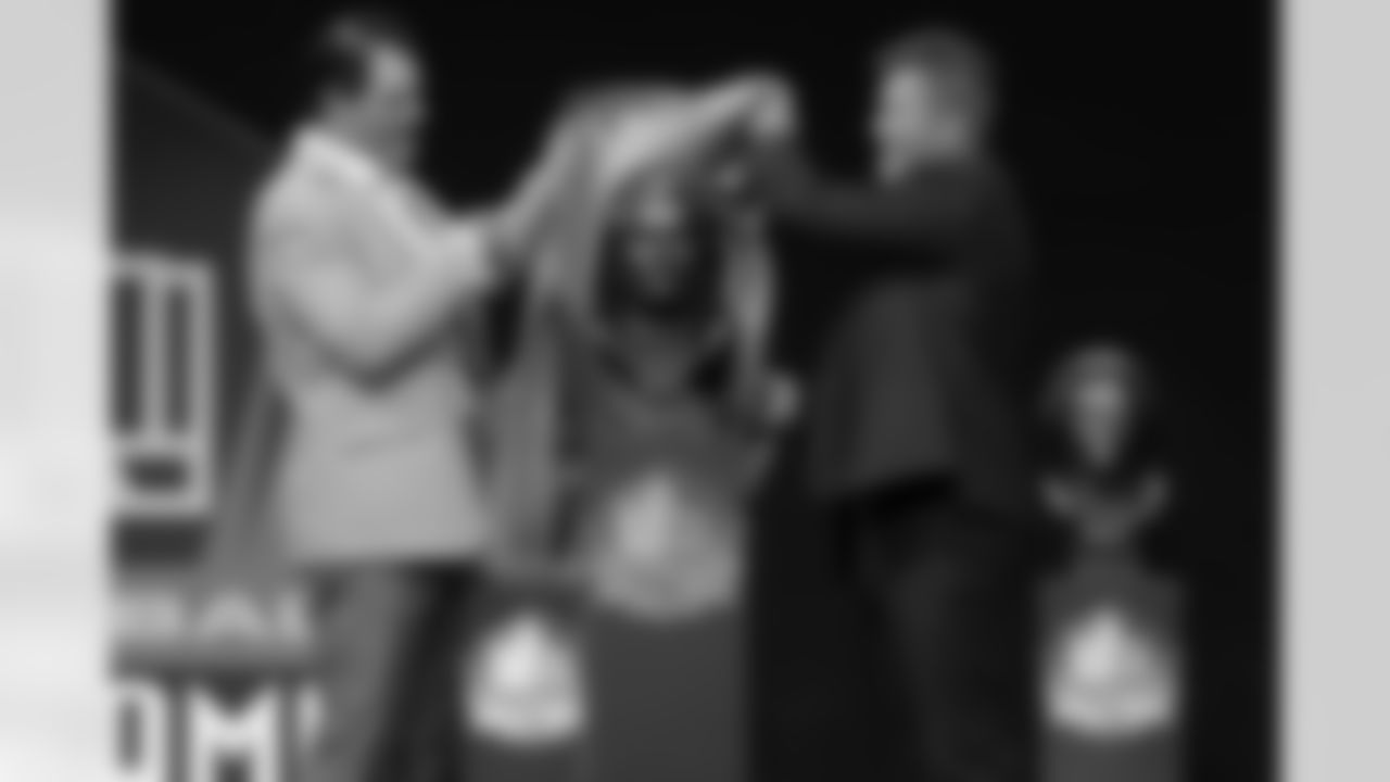 Steve Hutchinson lifts the cover off his bust during the Pro Football Hall of Fame Class of 2020 Enshrinement Ceremony on Saturday, August 7, 2021 in Canton, Ohio. (Aaron Doster/NFL)