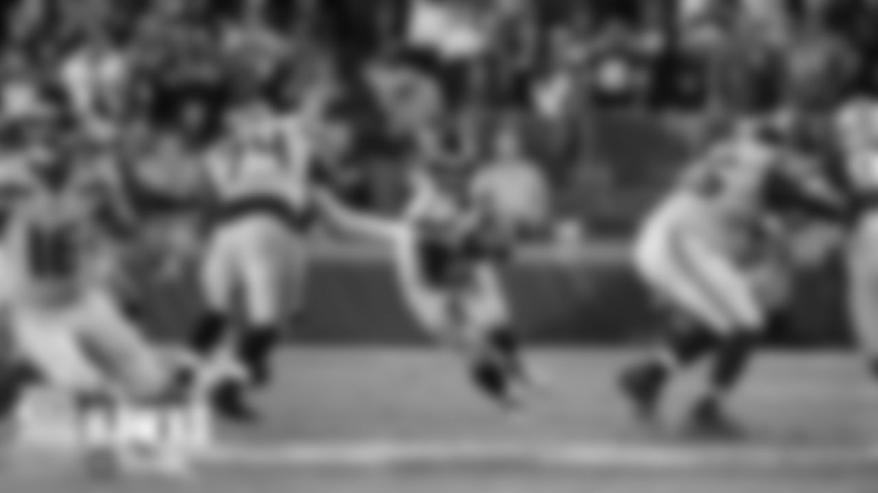 Seahawks quarterback Russell Wilson steps up as George Fant and Germain Ifedi provide a running lane.